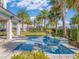 Backyard featuring in ground pool and jacuzzi with custom pool decking and a mature landscape at 985 Jack Nicklaus Ct, Kissimmee, FL 34747