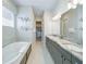 Luxurious bathroom featuring a soaking tub, double vanity with marble countertop, and walk-in closet at 985 Jack Nicklaus Ct, Kissimmee, FL 34747