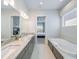 Bright bathroom featuring double vanity, marble counters, soaking tub and view of the main bedroom at 985 Jack Nicklaus Ct, Kissimmee, FL 34747