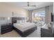 Bright bedroom with a dark wood bed frame, ceiling fan, and sliding glass doors to a balcony at 985 Jack Nicklaus Ct, Kissimmee, FL 34747