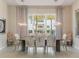 Dining room featuring modern light fixture, large table, and window views of the landscaping at 985 Jack Nicklaus Ct, Kissimmee, FL 34747