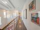 Second floor hallway featuring hardwood floors, modern railings, and decorative wall art at 985 Jack Nicklaus Ct, Kissimmee, FL 34747