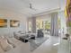 Bright living room with neutral decor, tile floors, and sliding doors for easy access to the yard at 985 Jack Nicklaus Ct, Kissimmee, FL 34747