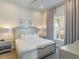 Bright and airy main bedroom with neutral colors, window, and side tables with lamps at 985 Jack Nicklaus Ct, Kissimmee, FL 34747