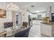 Elegant dining area with a glass table, tufted chairs, and views to the bright, updated kitchen at 1004 Sunwood Lane Ln, Orlando, FL 32807