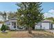 Charming single-story home with a cozy front porch, garage, and mature landscaping at 1004 Sunwood Lane Ln, Orlando, FL 32807