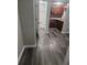 Hallway with a glimpse of the bathroom and kitchen, and grey wood-look flooring at 1004 Sunwood Lane Ln, Orlando, FL 32807