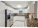 Well-lit kitchen featuring white cabinetry, stainless steel appliances, and speckled granite countertops at 1004 Sunwood Lane Ln, Orlando, FL 32807