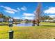 Scenic community view featuring a pond, dog waste station, lush greenery, and residential buildings at 10226 Vickers Ridge Dr, Orlando, FL 32829