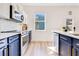 Well-equipped kitchen with modern stainless appliances and blue and white cabinetry at 10226 Vickers Ridge Dr, Orlando, FL 32829