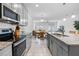 Modern kitchen with granite countertops and stainless steel appliances overlooks an open floor plan at 10358 Spring Arbor Ln, Winter Garden, FL 34787