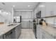 Modern kitchen featuring gray cabinets, granite countertops, and stainless steel appliances at 10358 Spring Arbor Ln, Winter Garden, FL 34787