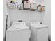 Functional laundry room with a washer, dryer, and storage shelves at 10358 Spring Arbor Ln, Winter Garden, FL 34787