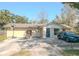 View of single-story home featuring a blue front door and a spacious driveway and an basketball hoop at 1041 Vihlen Rd, Sanford, FL 32771