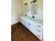 Bathroom with dual sinks, black hardware, and white cabinetry with a light countertop at 11 Spruce Ln, Ocala, FL 34472