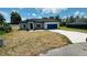 Charming single-story home showcasing a well-manicured lawn and a blue two-car garage at 11 Spruce Ln, Ocala, FL 34472