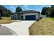 Charming single-story home showcasing a well-manicured lawn and a blue two-car garage at 11 Spruce Ln, Ocala, FL 34472