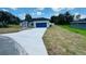 Charming single-story home showcasing a well-manicured lawn and a blue two-car garage at 11 Spruce Ln, Ocala, FL 34472