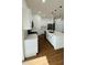 Modern kitchen with white cabinets, stainless steel appliances, quartz countertops and view into the living area at 11 Spruce Ln, Ocala, FL 34472