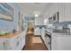 Well-lit kitchen boasts white cabinetry, modern appliances, and stylish backsplash, seamlessly flowing into the adjacent dining area at 111 Clark St, Oviedo, FL 32765