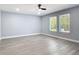 A spacious bedroom with light wood floors, a ceiling fan, and well-lit windows at 1125 E Hubbard Ave, Deland, FL 32724