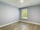 Cozy bedroom with wood-look floors, a window with natural light, and neutral wall color at 1125 E Hubbard Ave, Deland, FL 32724