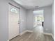 Inviting home entryway featuring light gray paint, white trim and a view of the kitchen with wood-look floors at 1125 E Hubbard Ave, Deland, FL 32724