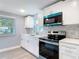 Beautiful kitchen featuring stainless steel appliances, gray backsplash, and a view of the neighborhood at 1125 E Hubbard Ave, Deland, FL 32724