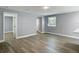 Bright living room features wood-look flooring, light grey walls, and natural light from a window at 1125 E Hubbard Ave, Deland, FL 32724