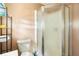 Small bathroom includes toilet, shower with sliding glass doors, and storage shelves at 1213 Cr 652, Bushnell, FL 33513