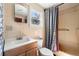 Cozy bathroom featuring a toilet, sink, and shower with patterned curtains, and a mirrored cabinet at 1213 Cr 652, Bushnell, FL 33513