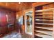 Cozy living room featuring wood paneling, shelving, and access to the kitchen at 1213 Cr 652, Bushnell, FL 33513