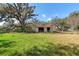 Exterior view of an old shed with fenced yard and mature tree overhead at 1213 Cr 652, Bushnell, FL 33513