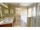 Bright bathroom featuring double sinks, a soaking tub, and a separate glass shower at 13812 Cepheus Dr, Orlando, FL 32828