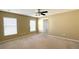 Large bedroom with neutral carpeting, a ceiling fan, and two large windows at 13812 Cepheus Dr, Orlando, FL 32828