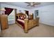 Primary bedroom showcasing a king-size bed, dark red curtains, and an overhead ceiling fan at 13812 Cepheus Dr, Orlando, FL 32828