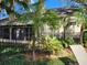 Backyard view featuring a black fence, palms, plants, and partial view of a lounge chair at 1567 Farrindon Cir # 1567, Lake Mary, FL 32746