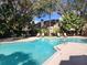 A large community pool with lounge chairs and umbrellas surrounded by trees at 1567 Farrindon Cir # 1567, Lake Mary, FL 32746