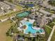 Aerial view of the community pool, tennis courts, clubhouse, parking, and surrounding neighborhood at 17826 Blazing Star Cir, Clermont, FL 34714