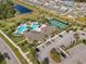 Aerial view showcasing a community pool, tennis courts, clubhouse, parking, and surrounding neighborhood at 17826 Blazing Star Cir, Clermont, FL 34714