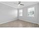 Bright bedroom featuring tile floors, neutral walls, ceiling fan, and windows at 17826 Blazing Star Cir, Clermont, FL 34714