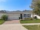 Charming one-story home with a two-car garage, lovely landscaping, and brick driveway at 17826 Blazing Star Cir, Clermont, FL 34714