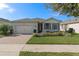 Charming single-story home boasts a well-manicured lawn, brick driveway, and a welcoming facade at 17826 Blazing Star Cir, Clermont, FL 34714