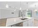 Spacious kitchen island with quartz countertop, double sink, and stainless steel dishwasher at 17826 Blazing Star Cir, Clermont, FL 34714