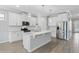 Modern kitchen featuring white cabinetry, stainless steel appliances, an island, and wood-style tile flooring at 17826 Blazing Star Cir, Clermont, FL 34714