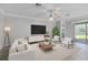 Bright living room with a neutral color palette, ceiling fan, and sliding glass doors to the backyard at 17826 Blazing Star Cir, Clermont, FL 34714