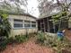 Spacious backyard with lush greenery and views of the home's exterior and screened porch at 22 Poinsettia Dr, Deland, FL 32724