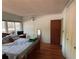 Well lit bedroom features wood floors, large bed, and open doorway at 22 Poinsettia Dr, Deland, FL 32724