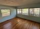 This bedroom showcases large windows, allowing ample natural light, and hardwood floors at 22 Poinsettia Dr, Deland, FL 32724