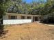 A single-story home with brick accents, green roof, and shaded front yard at 22 Poinsettia Dr, Deland, FL 32724
